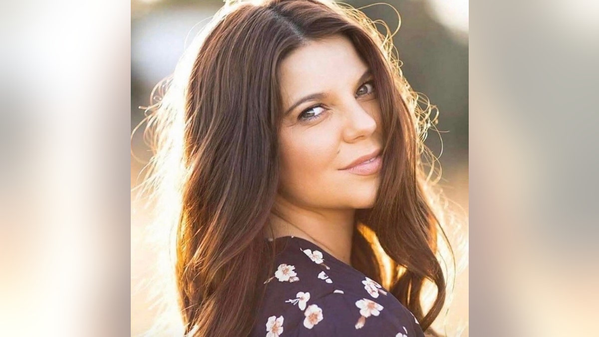 Amy Duggar Rey tomando una foto glamorosa al aire libre antes del lanzamiento de su libro.