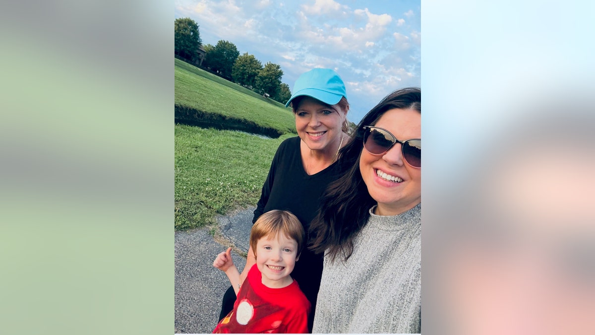 Amy Duggar King tomándose un selfie con su madre y su hijo mientras sonríen.
