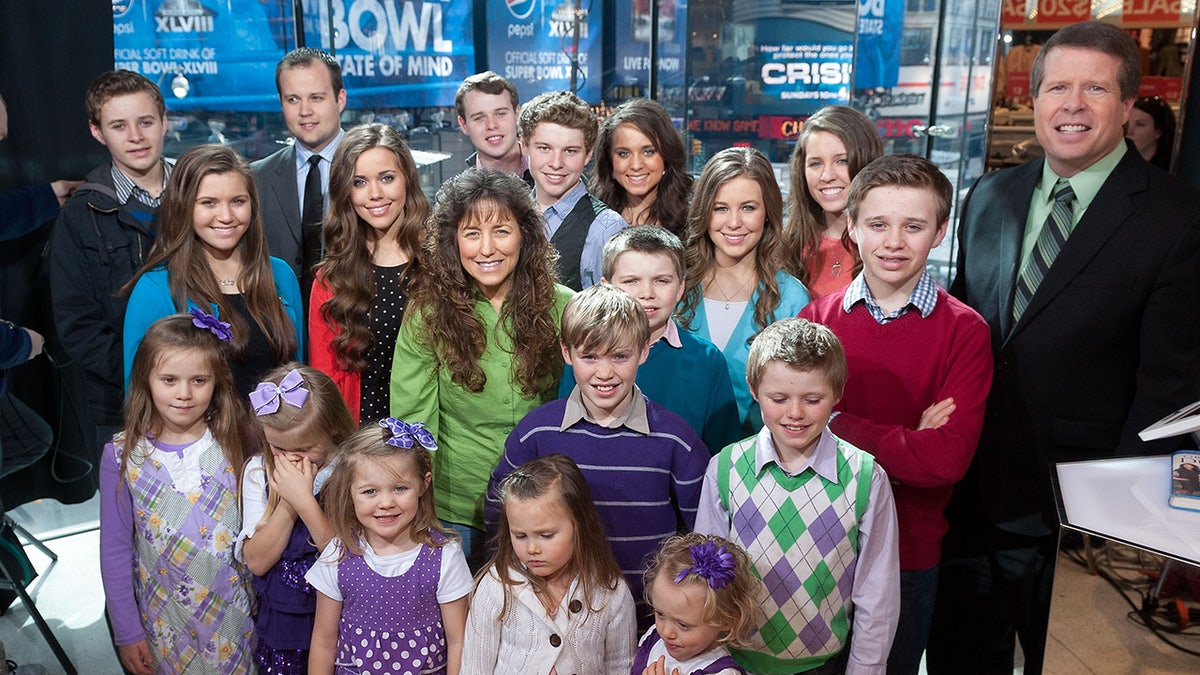 Jim Bob Duggar sonriendo con sus hijos en un estudio.