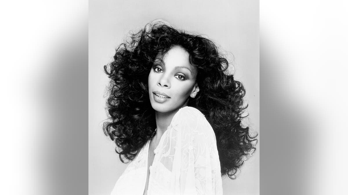 Una foto en blanco y negro de donna Summer con un vestido blanco.