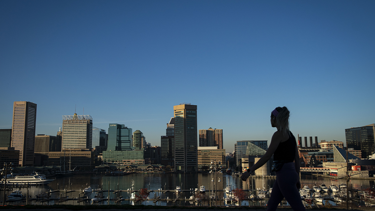 Un peatón camina por el horizonte del centro de Baltimore en Federal Hill park en Baltimore, Maryland, EE. UU. Fotógrafo: Al Drago / Bloomberg a través de Getty Images