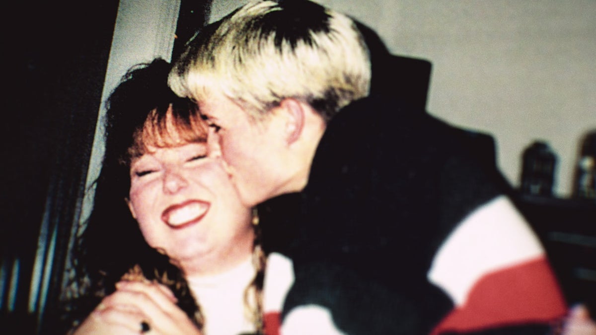 Amy Bradley besando a una mujer sonriente en la mejilla.