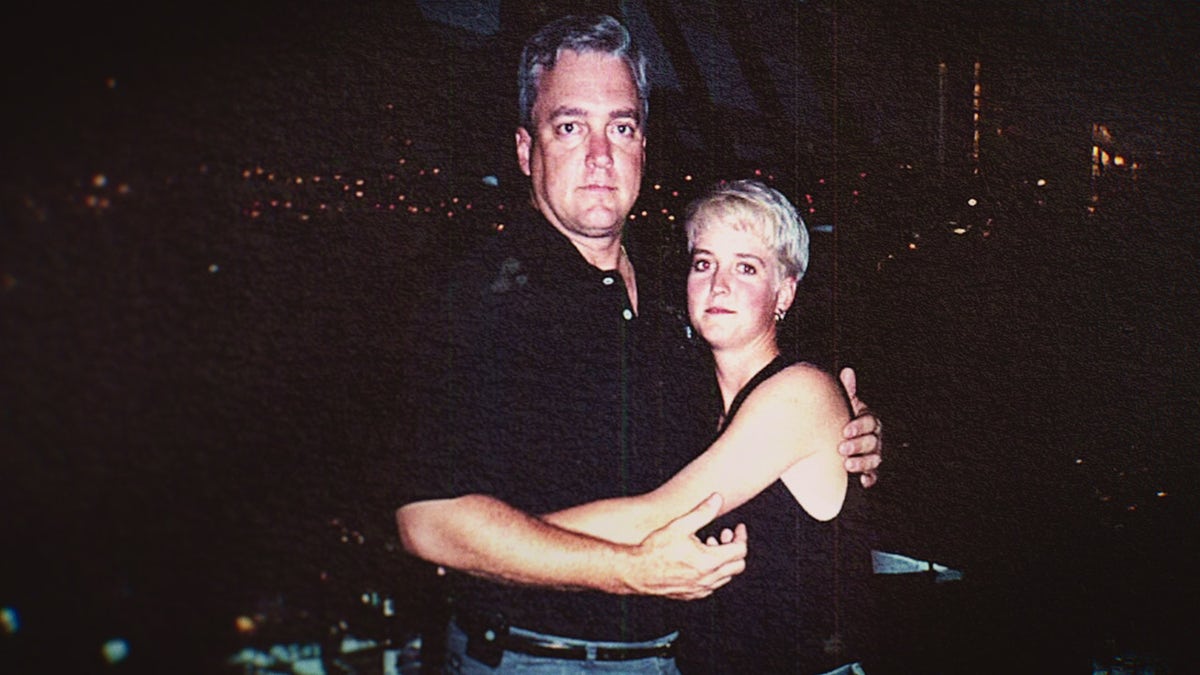 Amy Bradley con un vestido negro siendo sostenida por su hermano también vestido de negro.