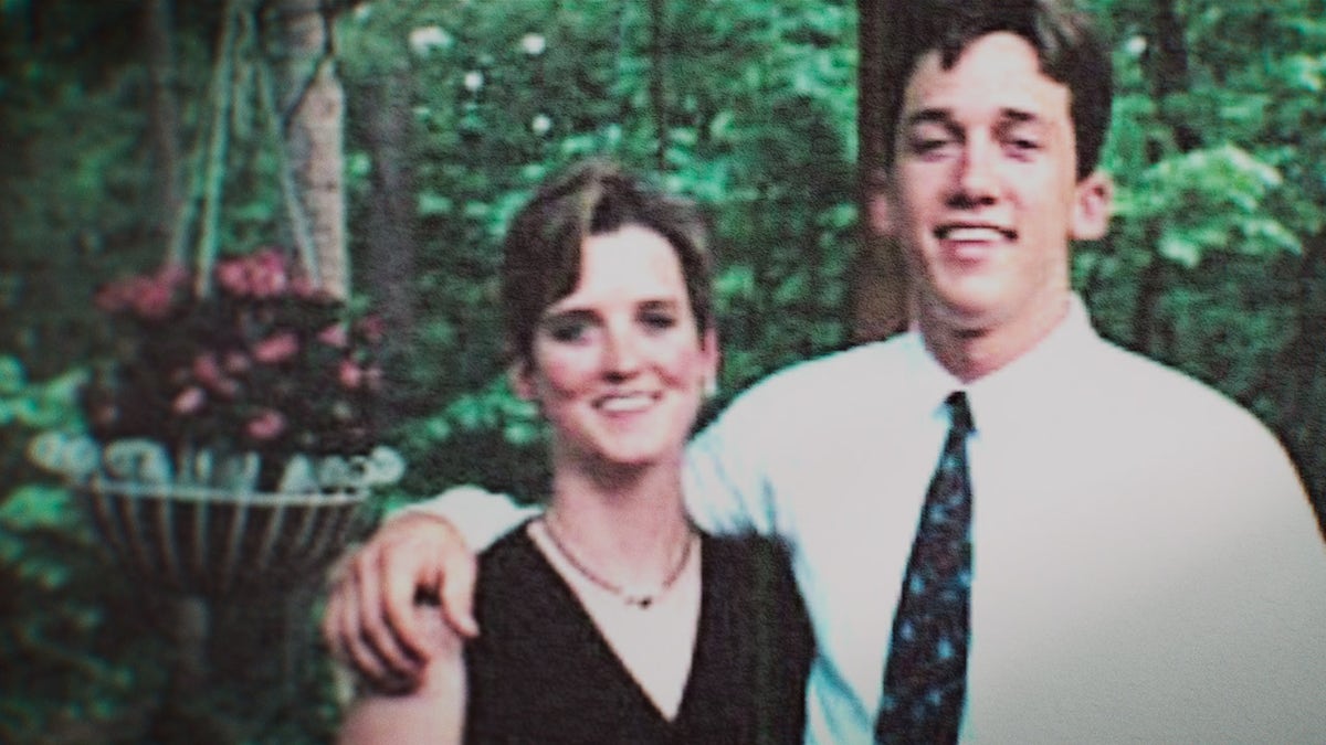 Amy Bradley con un vestido negro de tiras siendo abrazada por su hermano.