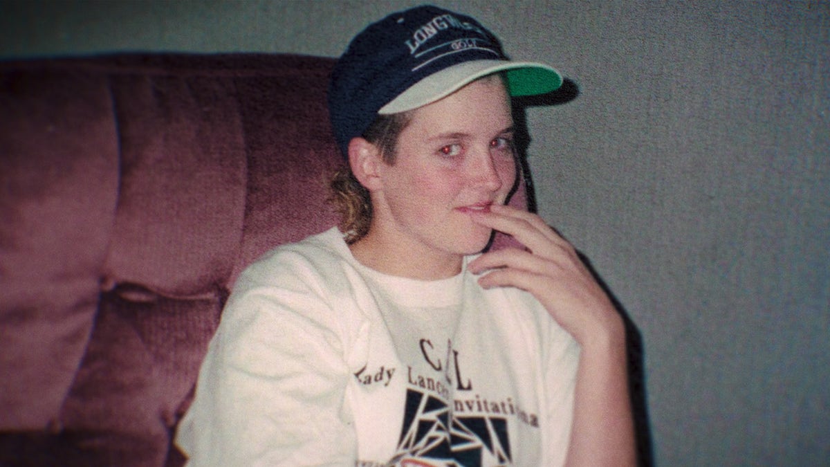 Amy Bradley vistiendo una camisa blanca con estampado negro y una gorra.