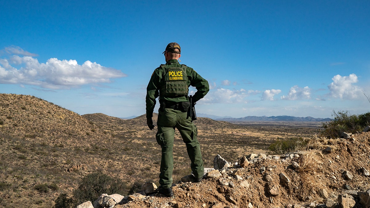 agente de la patrulla fronteriza se para en un acantilado en Arizona