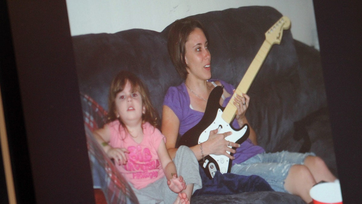 Caylee Anthony sentada junto a su madre Casey Anthony tocando la guitarra