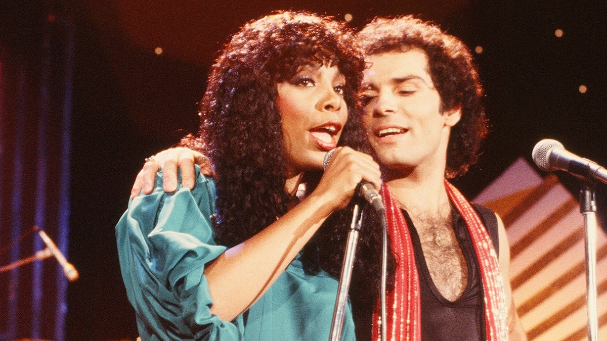 Donna Summer con un vestido verde cantando junto a Bruce Sudano