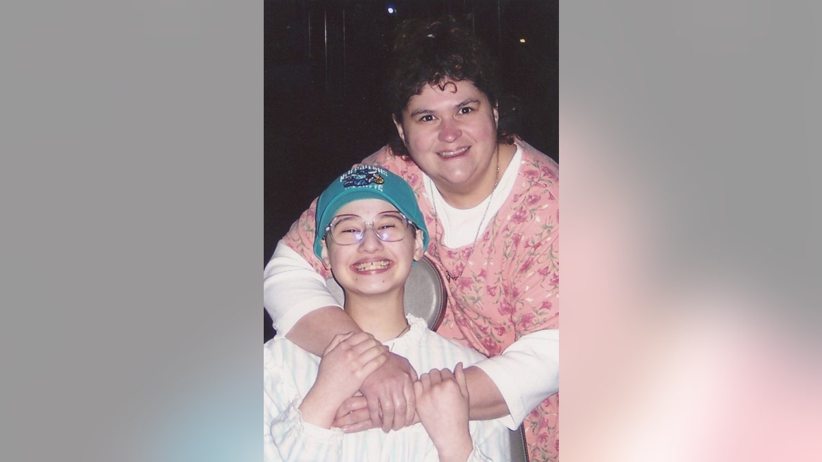 Gypsy Blanchard (izquierda) en silla de ruedas y Dee Dee Blanchard (derecha) con los brazos alrededor de Gypsy