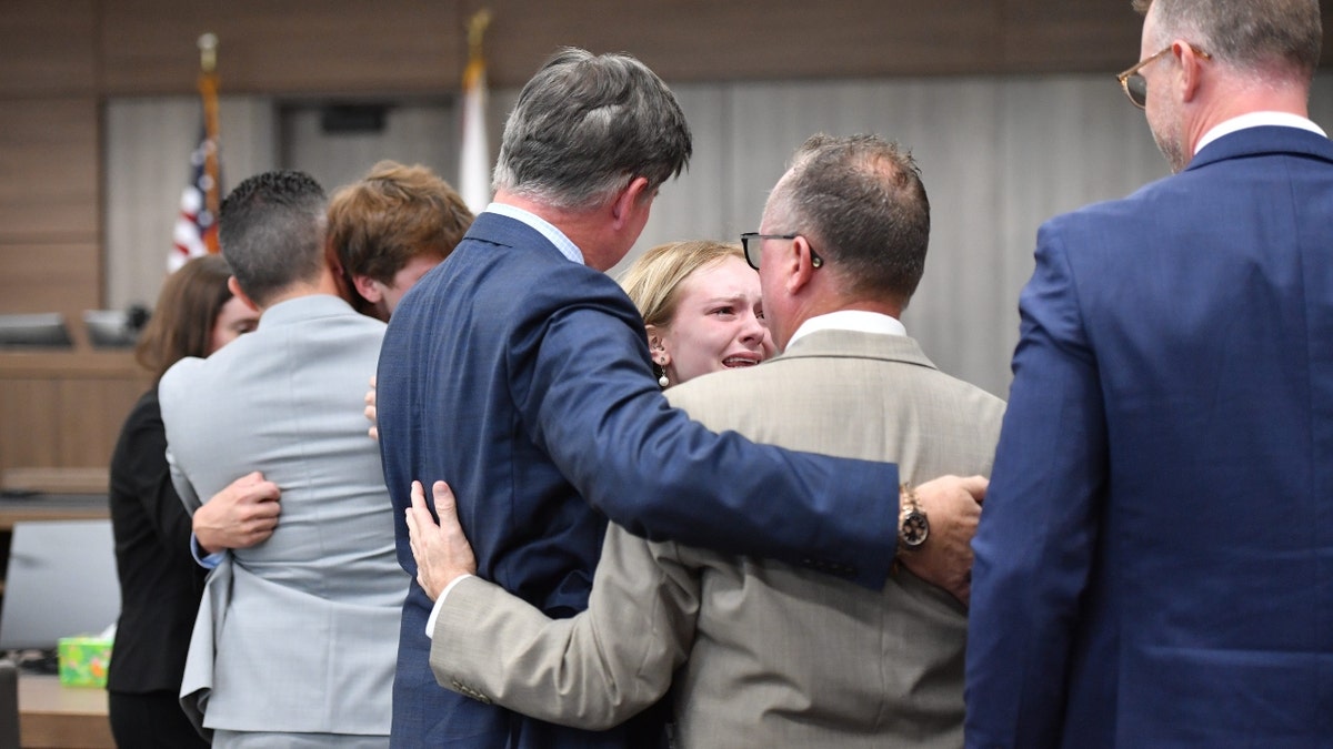 Maya Kowalski llora mientras abraza a sus abogados al concluir su juicio