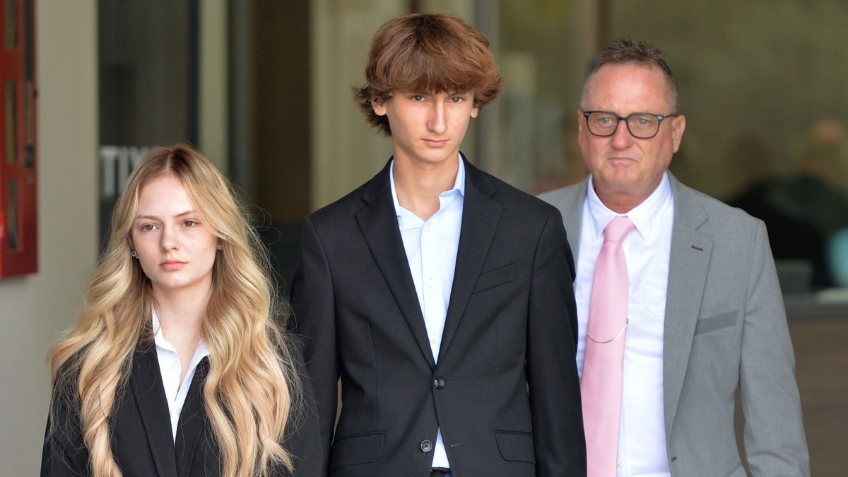 Maya Kowalski; su hermano, Kyle Kowalski; y su padre, Jack Kowalski, caminan uno al lado del otro