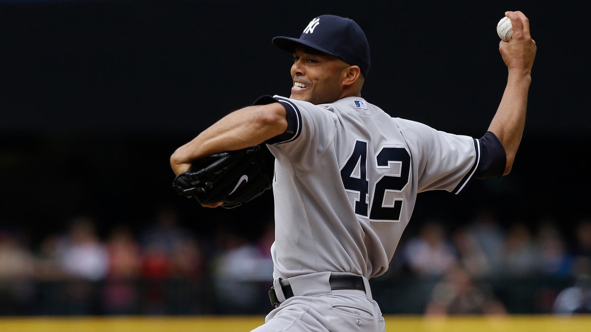 El pitcher cerrador de los Yankees de Nueva York, Mariano Rivera, lanza en la novena entrada de un partido de béisbol contra los Marineros de Seattle, el domingo 9 de junio de 2013, en Seattle. Rivera se ganó el salvamento y los Yankees derrotaron 2-1 a los Marineros. (AP Photo/Ted S. Warren)