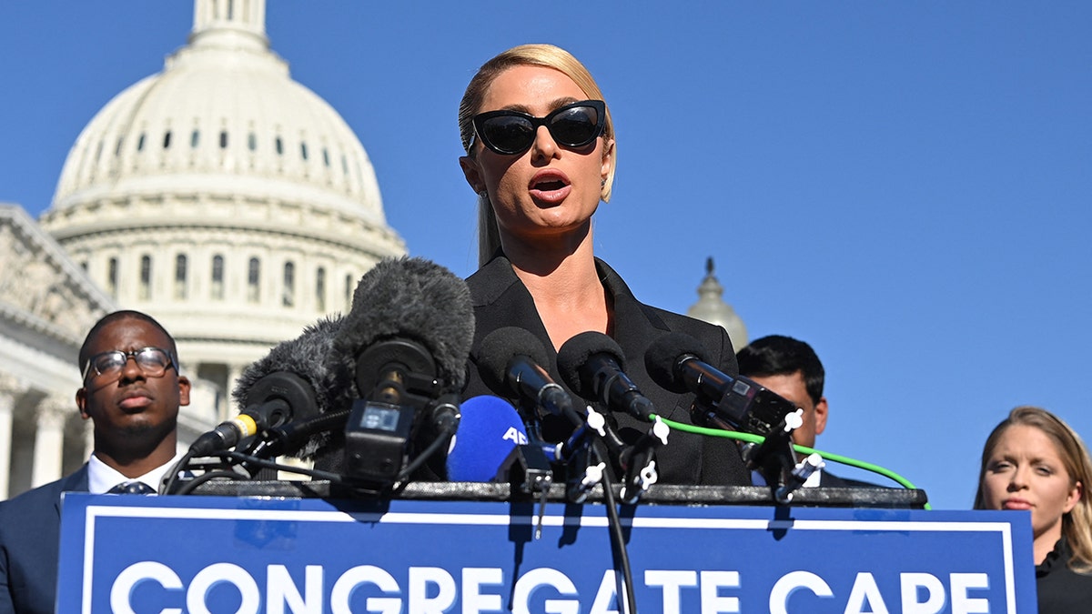 Paris Hilton hablando con la cúpula del Capitolio detrás de ella