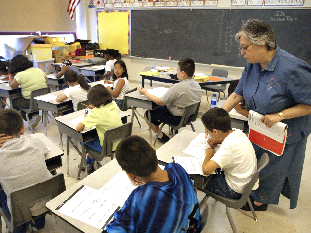 La maestra Arlene Lebowitz ayuda a una estudiante en su clase de tercer grado durante la escuela de verano Ju